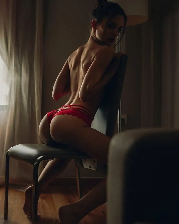 femme assise de dos en lingerie rouge sur chaise