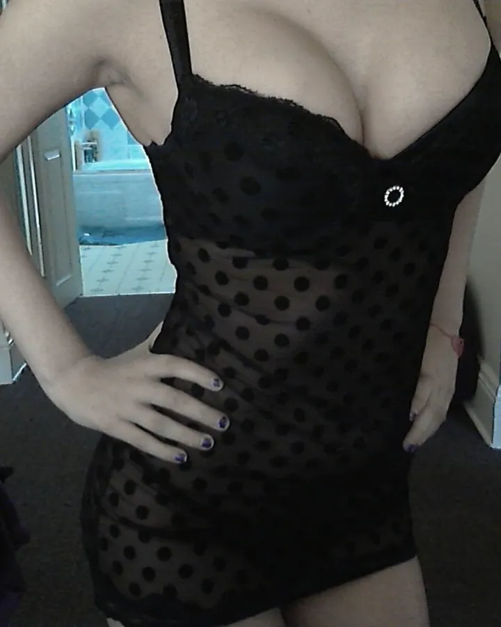 femme en nuisette noire à pois, main sur hanche