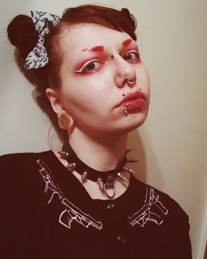 Femme arabe de 25-35 ans, cheveux châtains, portant un string noir, debout près d'une fenêtre.